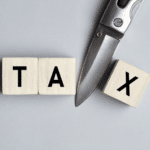 a knife cutting the word tax to illustrate tax deduction and tax credit